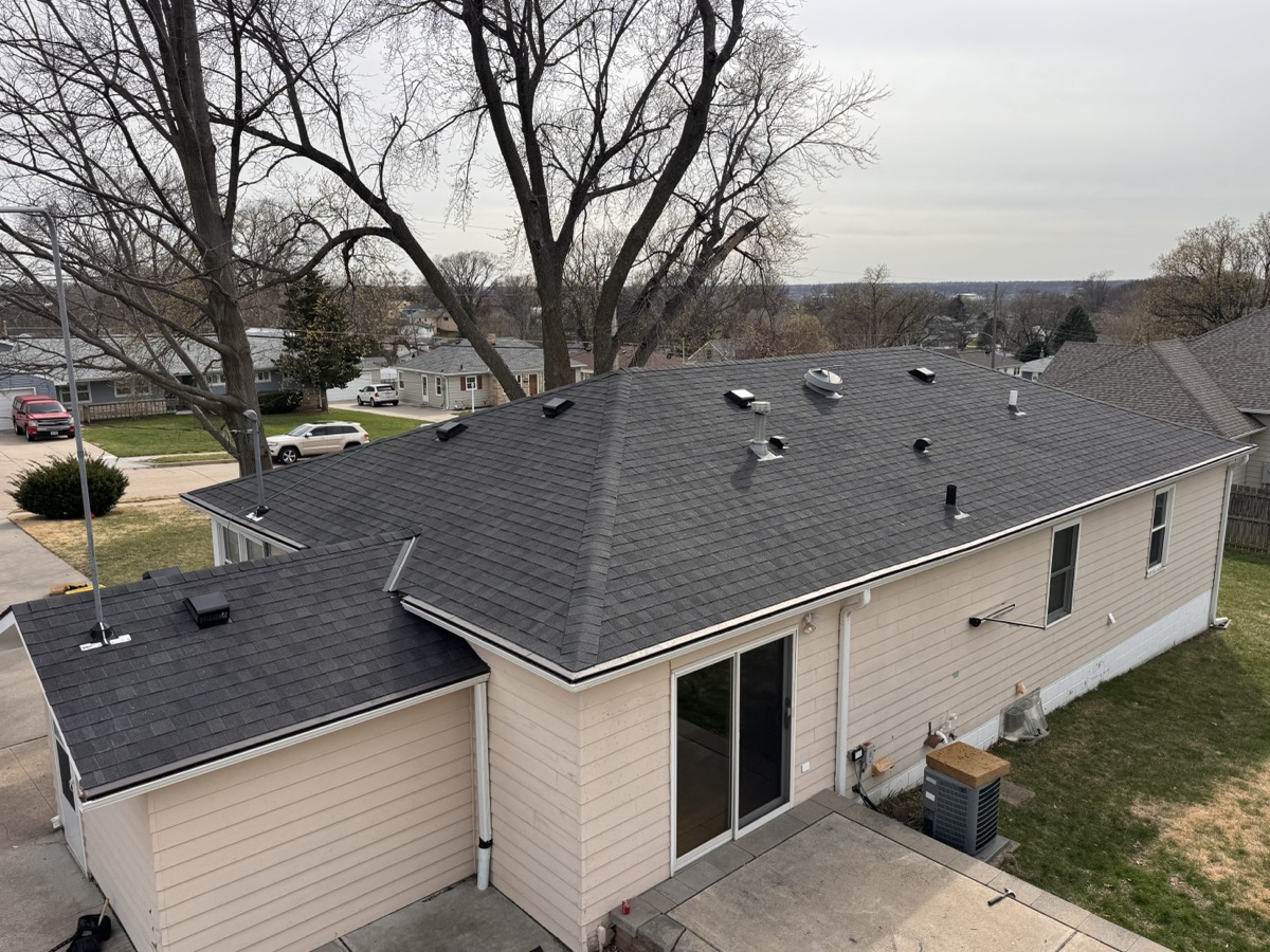Reliable roof replacement keeps your home sealed against harsh weather. A wide-angle shot of a finished roof replacement with uniform shingle rows and clean gutters. width=
