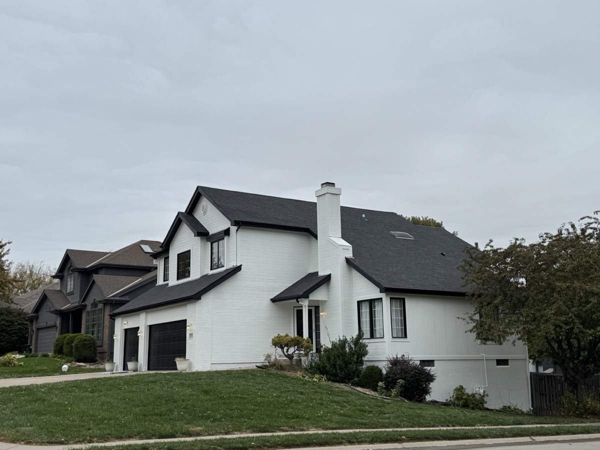 Seamless gutter systems protect your foundation from water damage. A professionally installed aluminum gutter and downspout system running along the roofline of a home. width=